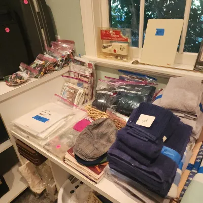 Assortment of household linens, sewing notions, craft supplies, and accessories, including a vintage Mini Mender hand-held sewing machine.
