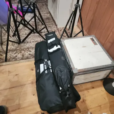 Sale Photo Thumbnail #150: Collection of photography equipment including black metal light stands, softshell carrying cases, and a hard shell Fiberbilt transport case.