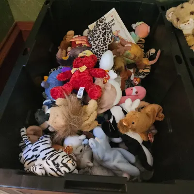 Large black plastic storage bin filled with an assortment of vintage Ty Beanie Babies and plush toys from the 1990s.