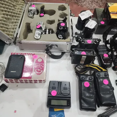 Collection of vintage camera equipment and photography accessories, including 35mm film SLR bodies in a fitted hard case, Sekonic light...