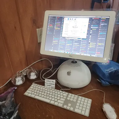 Vintage Apple iMac G4 computer setup, including a white 'sunflower' base with articulated LCD monitor, white wired keyboard,...