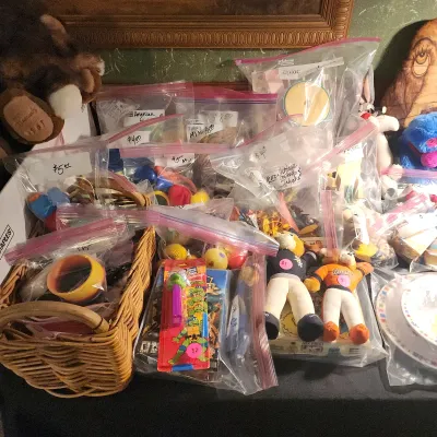 Sale Photo Thumbnail #103: Collection of small vintage toys, plush figures, and novelty items individually packaged in plastic ziplock bags with price tags, alongside a woven basket.