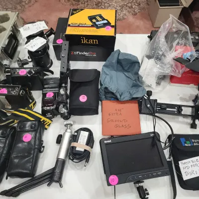Collection of camera gear and accessories, including a Marshall field monitor, Ikan smart charger in box, tripod heads, leather cases,...
