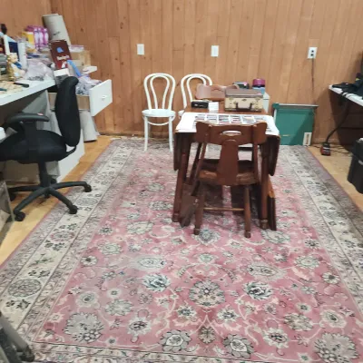 Large oriental-style area rug featuring a muted pink field with intricate floral medallions and a broad cream border, paired with an...