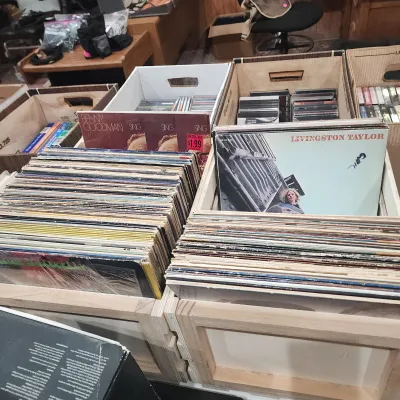 Collection of vintage vinyl LP records organized in wooden crates, featuring albums by Livingston Taylor and Benny Goodman alongside...