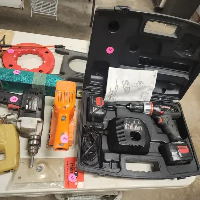 Sale Photo Thumbnail #139: Craftsman 12.0 Volt cordless drill kit in original hard case alongside assorted vintage power tools, including a corded drill, hand sander, and jigsaw.