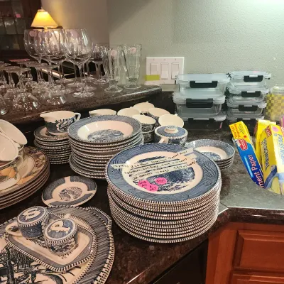 Sale Photo Thumbnail #118: Large set of blue and white Currier & Ives transferware dishware displayed on a countertop alongside glassware and food storage containers.