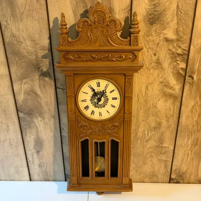 Sale Photo Thumbnail #145: Vintage Syroco molded plastic wall clock with an ornate wood-look finish, carved scroll pediment, and decorative pendulum.