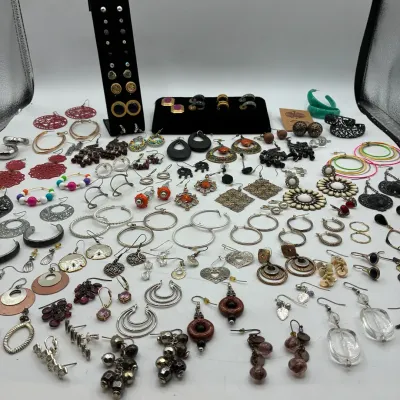 Sale Photo Thumbnail #191: Large assortment of costume jewelry earrings including hoop, dangle, and stud styles in various metals and colors.