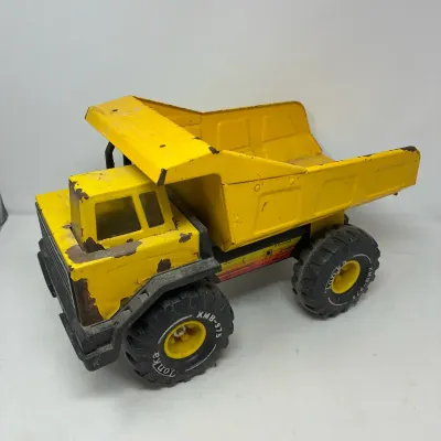 Sale Photo Thumbnail #164: Vintage yellow Tonka pressed steel dump truck showing play wear and surface rust.