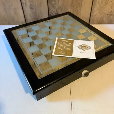 Sale Photo Thumbnail #58: Shannon Crystal by Godinger chess board featuring a mirrored top with etched glass playing squares, a black wooden frame, and a crystal knob drawer.