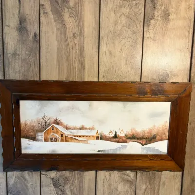 Sale Photo Thumbnail #142: Vintage winter landscape painting depicting a snowy farm scene with barns and a bridge, housed in a carved dark wood frame.