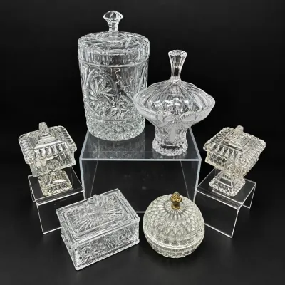 Sale Photo Thumbnail #162: Collection of six vintage cut and molded clear glass covered jars and trinket boxes, featuring intricate geometric and starburst patterns.