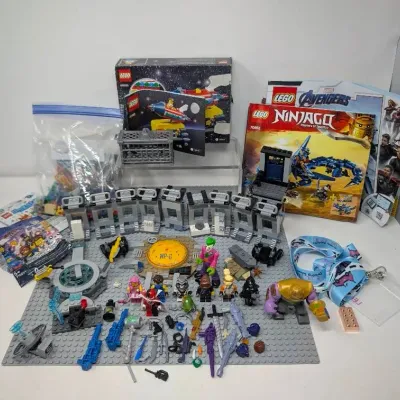 Sale Photo Thumbnail #98: Assorted Lego sets and minifigures including Marvel Avengers and Ninjago themes, complete with instruction manuals and loose building pieces.