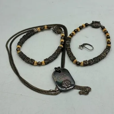 Sale Photo Thumbnail #198: Assortment of personalized bead name bracelets, a single solitaire earring, and a heavily tarnished diabetic medical ID tag on a chain.
