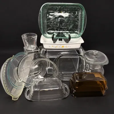 Sale Photo Thumbnail #41: Collection of vintage glass cookware and kitchenware, including Pyrex baking dishes, butter dishes, pie plates, and a measuring cup.