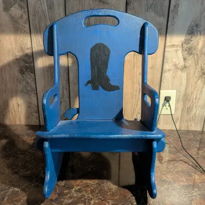 Sale Photo Thumbnail #116: Handcrafted blue wooden child's rocking chair featuring a stenciled black cowboy boot design on the backrest.