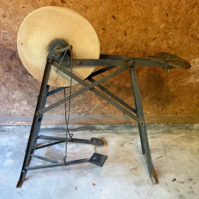 Sale Photo Thumbnail #83: Antique treadle-powered sharpening wheel on a cast iron frame with an integrated seat.