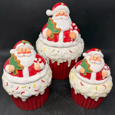 Sale Photo Thumbnail #15: Set of three ceramic Santa Claus cupcake-style jars, featuring glossy red and white glaze with sprinkle details.