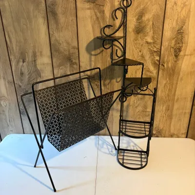 Sale Photo Thumbnail #146: Vintage black wrought iron mid-century magazine rack alongside a wall-mounted tiered corner plant shelf and a small freestanding metal rack.