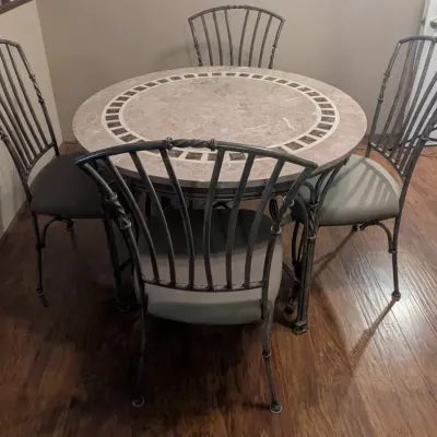 Sale Photo Thumbnail #45: Round stone-top dining table with tiled mosaic accent border and four matching wrought iron chairs featuring upholstered seats.