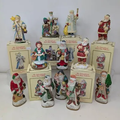 Sale Photo Thumbnail #159: Collection of resin figurines from The International Santa Claus Collection, featuring various historical and global depictions of Santa Claus with original boxes.