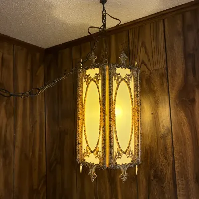 Sale Photo Thumbnail #189: Vintage Hollywood Regency style swag chandelier, featuring ornate brass-tone metal framework and frosted glass panels.