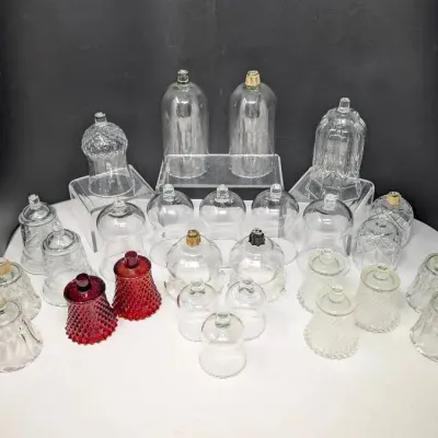 Sale Photo Thumbnail #154: Collection of vintage glass votive pegs and candle cups, featuring various molded, diamond-point, and swirl patterns in clear and ruby red glass.