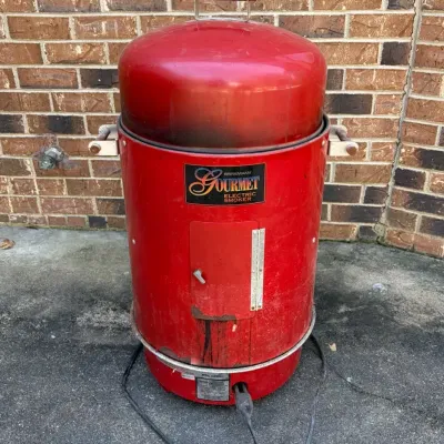 Sale Photo Thumbnail #72: Red Brinkmann Gourmet electric smoker showing signs of outdoor use and minor rust near the bottom.
