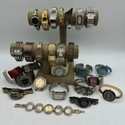 Sale Photo Thumbnail #201: Large assortment of fashion wristwatches, including cuff watches, rhinestone-accented designs, and link bracelet styles displayed on T-bar stands and laid out flat.