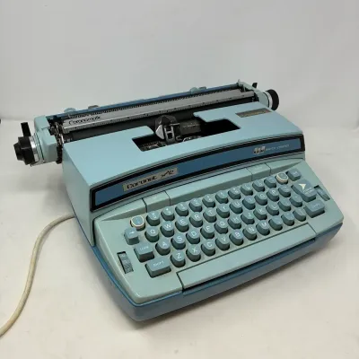 Sale Photo Thumbnail #176: Vintage SCM Smith-Corona Coronet Super 12 electric typewriter in light blue with attached power cord, circa 1970s.