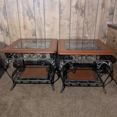Sale Photo Thumbnail #93: Pair of traditional end tables featuring glass-top wood frames over ornate black wrought iron bases with lower wood shelves.