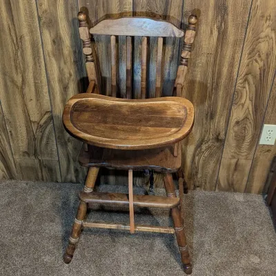 Sale Photo Thumbnail #8: Vintage dark-stained wooden high chair featuring a flip-over tray, spindle backrest, turned legs, and a built-in footrest.
