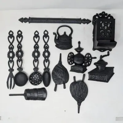 Sale Photo Thumbnail #158: Collection of black cast iron kitchen wall decor and miniatures, including decorative utensils, a kettle, coffee grinders, and a match holder.