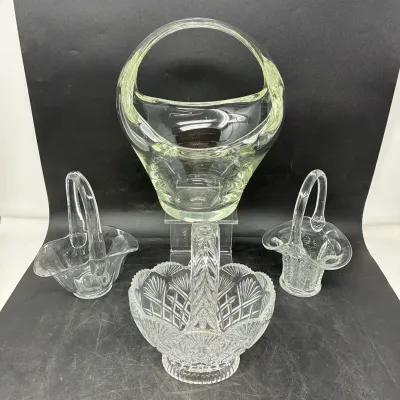 Sale Photo Thumbnail #183: Collection of four vintage clear glass decorative baskets, including one heavy cut crystal basket with crosshatch patterns and three blown glass baskets with arched handles.