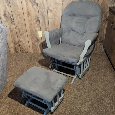 Sale Photo Thumbnail #92: Modern gray upholstered glider rocker chair with matching ottoman and painted wooden frame.