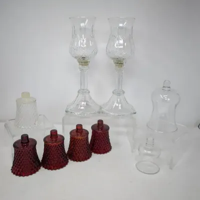 Sale Photo Thumbnail #126: Collection of vintage glass votive candle pegs, including four ruby red diamond-point cups, a pair of tall clear hurricane-style lamps, and assorted clear glass chimneys.