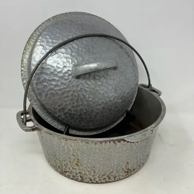 Sale Photo Thumbnail #179: Vintage hammered cast aluminum Dutch oven with matching lid and metal bail handle.