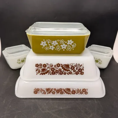 Sale Photo Thumbnail #14: Vintage Pyrex refrigerator dish set including olive green Spring Blossom and brown Woodland floral patterns with clear glass lids.