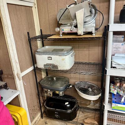 Sale Photo Thumbnail #28: Black metal wire shelving unit displaying small kitchen appliances, including a Eurodib commercial meat slicer, a vintage General Electric roaster, an electric skillet, and an Oster roaster oven.