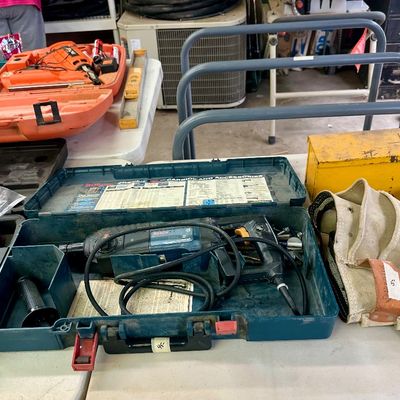 Sale Photo Thumbnail #19: Assortment of power tools in original hard cases, including a Bosch rotary hammer drill, along with a canvas tool pouch and a vintage metal toolbox.