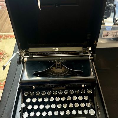 Vintage Royal portable typewriter in a glossy black finish, housed in its original hard carrying case.