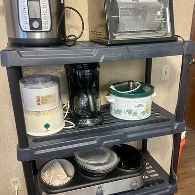 Sale Photo Thumbnail #57: Black plastic utility shelf unit displayed with various small kitchen appliances, including a Power Quick Pot pressure cooker, Ronco Showtime rotisserie oven, Mr. Coffee maker, and slow cookers.