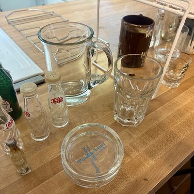 Sale Photo Thumbnail #62: Assortment of vintage glassware, including miniature Pepsi bottle salt and pepper shakers, a glass beer pitcher, a Paradise Island ashtray, and various drinking glasses.