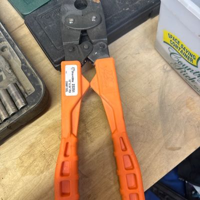 SharkBite 23251 1/2-inch and 3/4-inch PEX crimp tool with orange handles.