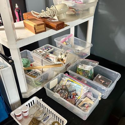 Sale Photo Thumbnail #40: Shelves and clear plastic storage bins filled with assorted small collectibles, including vintage patches, keychains, playing cards, beads, and wooden boxes.