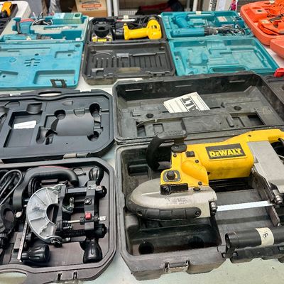 Sale Photo Thumbnail #21: Collection of power tools in original blow-molded carrying cases, including a DeWalt deep-cut portable band saw, cordless drills, and specialty cutting attachments.