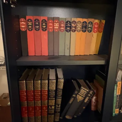 Sale Photo Thumbnail #67: Collection of vintage hardcover books housed in a dark bookcase, including Funk & Wagnalls encyclopedias and a set of classic novels with colorful spines.