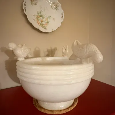 Sale Photo Thumbnail #6: Vintage white alabaster or marble birdbath-style bowl featuring carved birds resting along the rim, displayed below a floral porcelain wall plate.