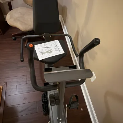 Sale Photo Thumbnail #63: Marcy recumbent exercise bike featuring a padded seat, backrest, and front handlebars with assembly manual.
